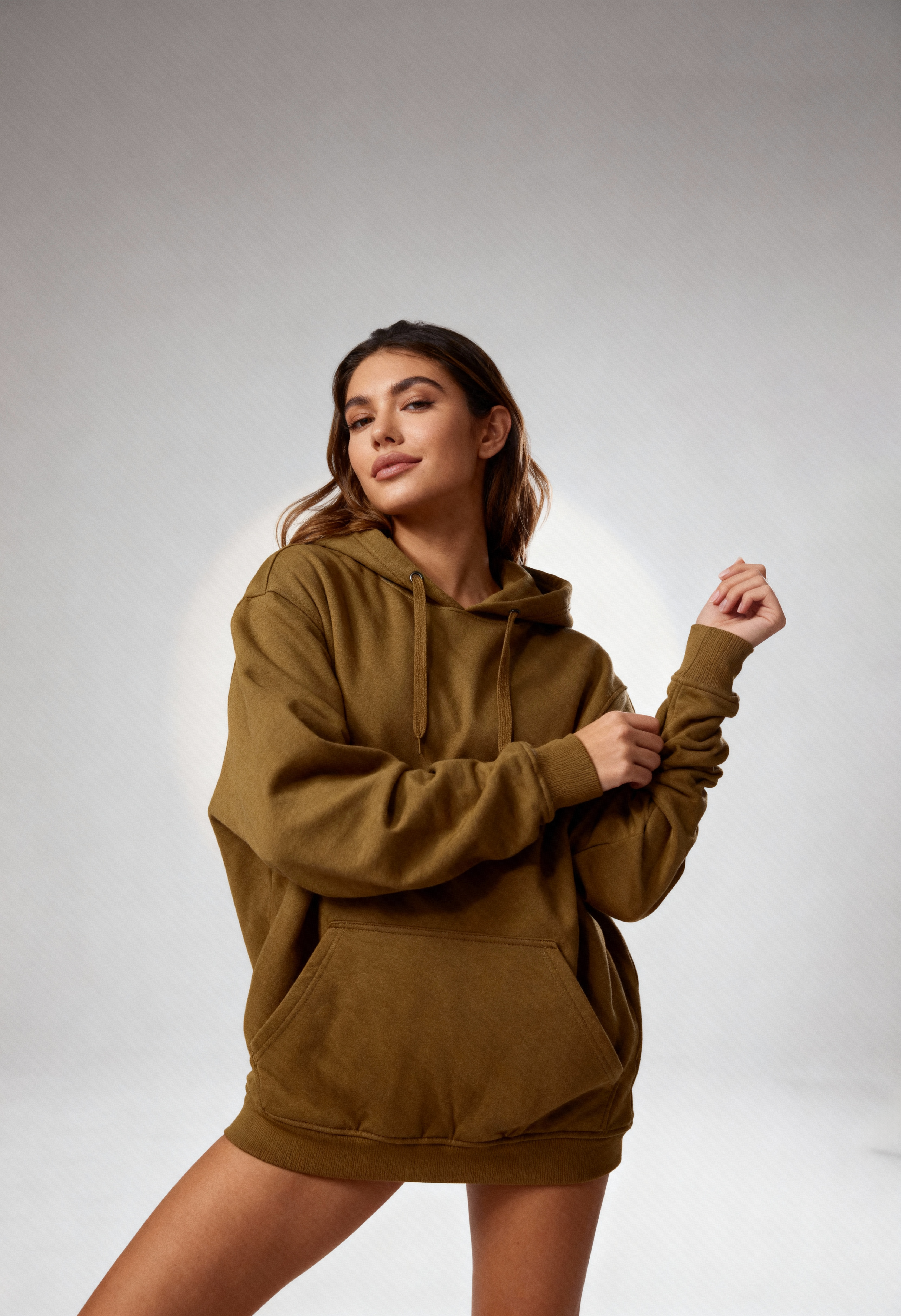 Woman wearing a brown caramel hoodie and shorts set on a light gray background