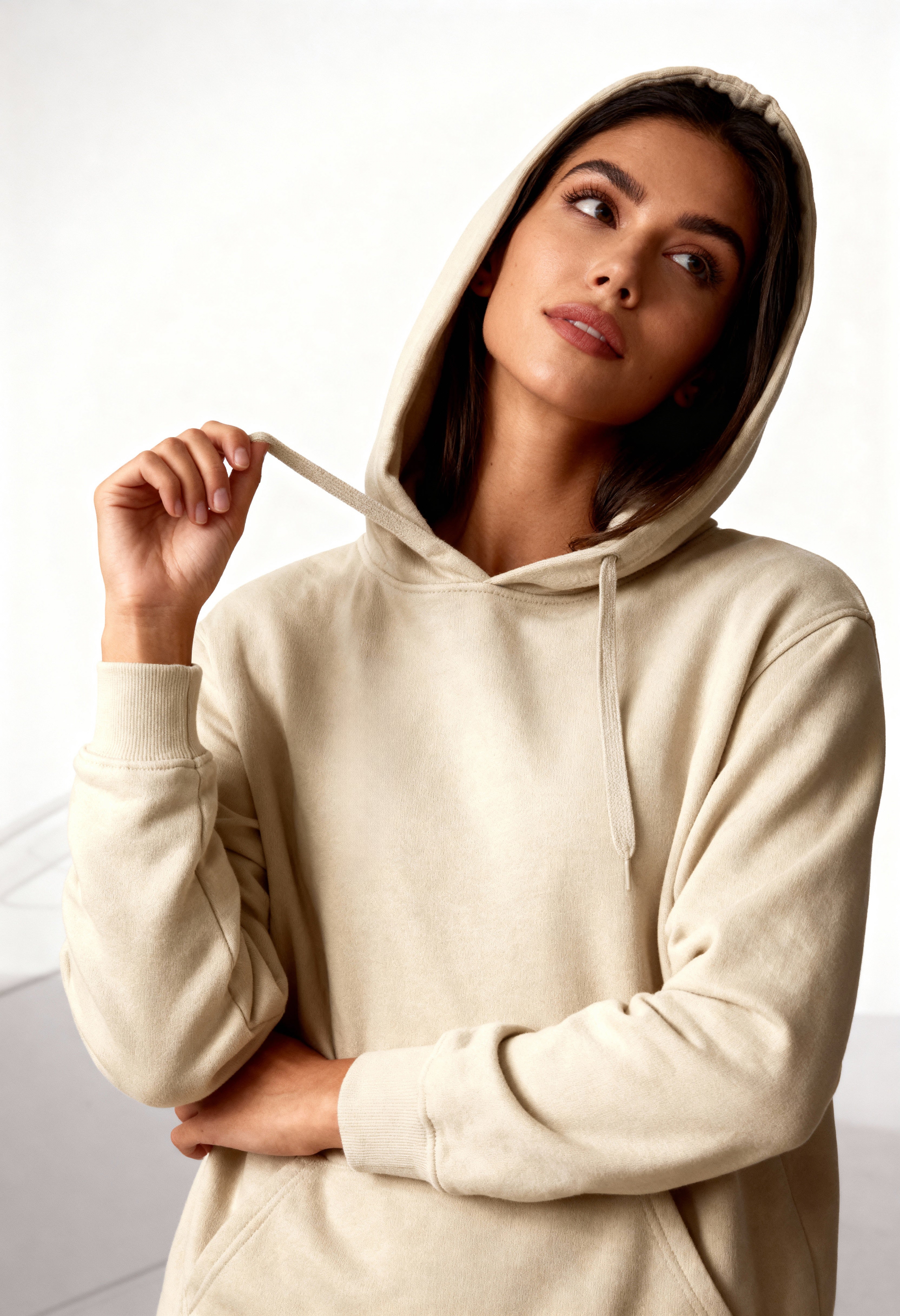 Woman wearing a beige hoodie against a white background